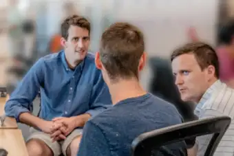 Three men talking, one interpreting for the others